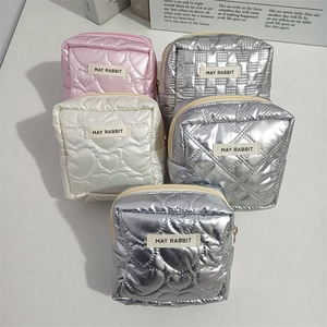 Close-up of heart-quilted and checkerboard pattern PU makeup bags with metal zippers