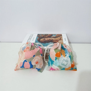 Detail of artistic floral drawstring bags with colorful oil painting textures and cotton ropes