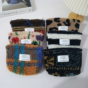 Detailed view of plush leopard and floral makeup bags with soft texture and zip closure