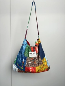 Detailed close-up of a large floral patchwork tote bag with 'SEE YOU' logo on soft fabric