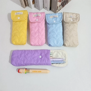 Detailed view of quilted heart pattern and snap closure on these soft fabric pouches