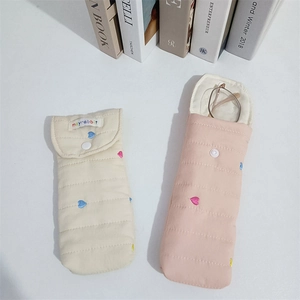 Close-up of quilted storage pouch with colorful heart embroidery and resin button closure