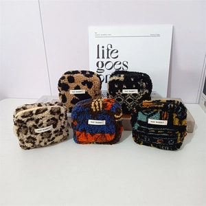 Close-up of five sherpa plush square pouches with assorted animal and floral prints