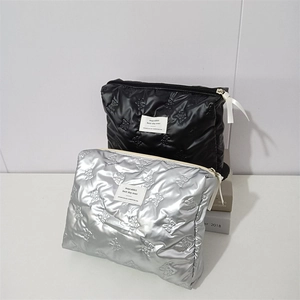 Detailed view of quilted PU makeup bag with 3D butterfly texture and ribbon zipper