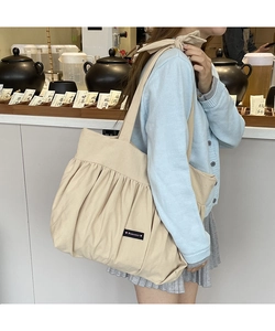Detail of cream cotton tote bag showing Romance label and soft pleated texture