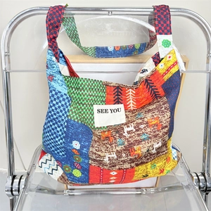 Ethnic style floral patchwork tote bag with SEE YOU text on stylish modern chair
