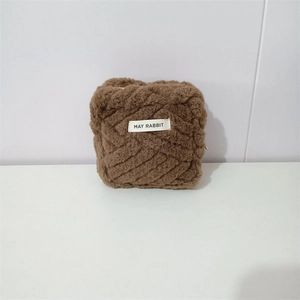 Macro detail of dark brown plush mini bag with MAY RABBIT label and soft ribbed texture