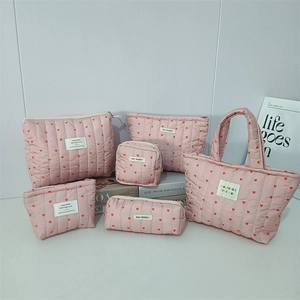 Collection of quilted pink cosmetic bags and pencil cases with red heart pattern print