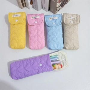 Detailed close-up of colorful heart quilted pencil cases with snap closure and soft fabric