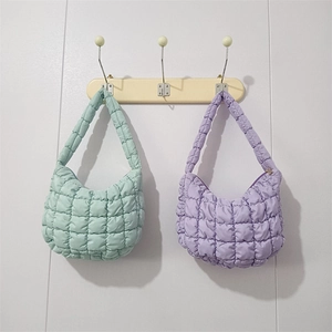 Quilted puffer cloud bags in mint green and lavender purple on wooden hooks