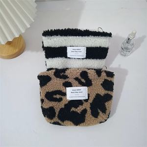 Detail of plush leopard print and striped toiletry bags with soft faux fur texture