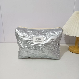 Detail of silver star quilted cosmetic bag with metal finish and zipper closure