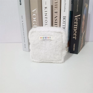 Nahaufnahme der weißen Plüschtasche mit mayrabbit-Webetikett auf einem Tisch