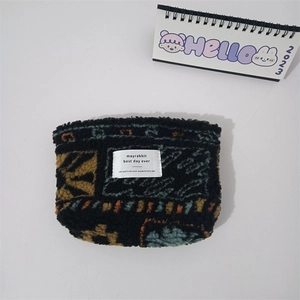 Detail of plush leopard print makeup bag with colorful geometric patterns and white label