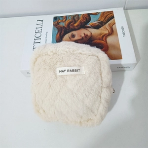 Close-up of white plush square organizer bag with MAY RABBIT label and metal zipper detail