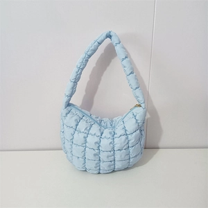 Detail of light blue quilted cloud bag showing puff checker pattern and soft texture