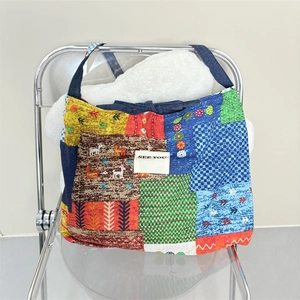 Bohemian patchwork denim tote bag with ethnic prints and SEE YOU tag hanging on chair