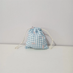 Detail of floral cotton drawstring bag showing blue checkered pattern and pink bows