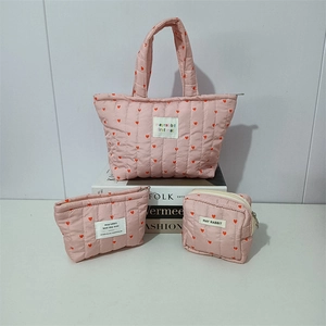 Three-piece set of pink quilted heart bags including tote and zipper pouches for storage