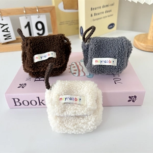 Three plush lamb wool mini headphone cases in brown, grey, and white with hanging cords