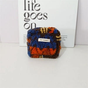 Detail of multi-color plush organizer bag with fluffy texture and brand patch