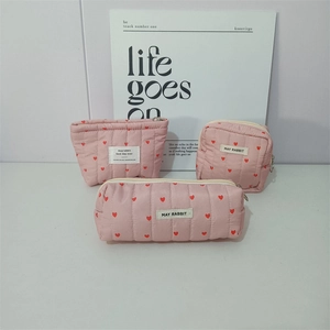 Three-piece pink quilted makeup bags set with red heart patterns and metal zippers