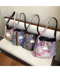 Detail view of four bohemian patchwork denim tote bags with floral patterns and SEEYOU label