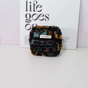 Close-up of plush geometric pattern sherpa bag with top zipper and woven label