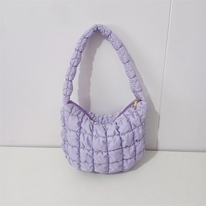 Close-up of lavender quilted puffer handbag featuring a grid texture and golden zipper detail
