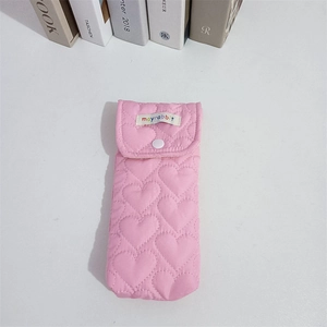 Close-up of pink quilted heart fabric storage pouch with snap closure and brand label