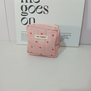 Detail of pink quilted handbag with red heart pattern and MAY RABBIT cloth label