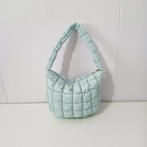 Detail of light mint green quilted puffy bag with bubble texture and gold zipper closure