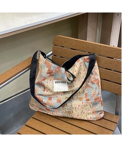 Detail view of ethnic floral patchwork denim tote with SEEYOU woven label decoration