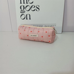 Close-up of pink quilted heart pouch with May Rabbit label and silver zipper pull