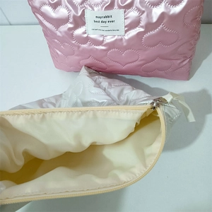 Macro view showing the heart-quilted texture and interior lining of these cosmetic bags