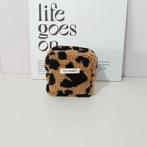 Detailed view of leopard print plush travel makeup bag with brand label and metal zipper
