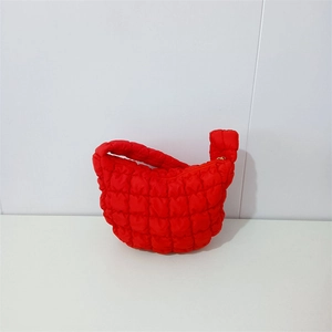 Detail of bright red quilted puffy hobo bag with distinctive square textured padding