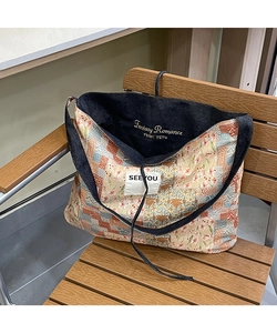 Close-up of ethnic patchwork denim tote with gold embroidery and interior lining detail