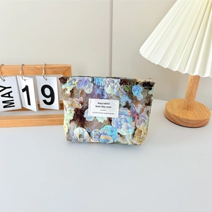 Detailed macro view of the floral canvas makeup bag with blue flowers and metal zipper