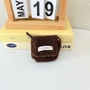 Close-up of deep brown plush earphone case with soft lamb wool texture and brand label