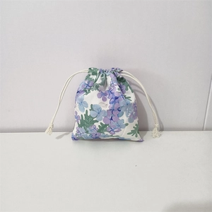 Detail of floral drawstring storage bag featuring blue and purple flower patterns
