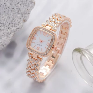 Vue macro latérale d'une montre carrée en or rose élégante sertie de cristaux brillants