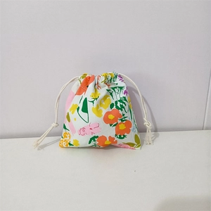 Detailed close-up of a floral cotton drawstring storage bag with a white cotton rope closure