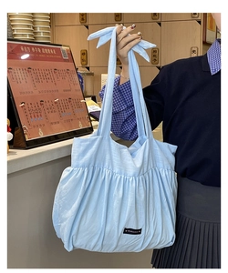Detailed texture of light blue cotton linen tote bag with soft pleated cloud design