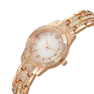 Detail of rose gold luxury watch showing sparkling rhinestone bezel and Roman numerals