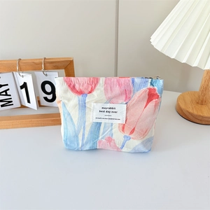 Detailed view of canvas makeup bag with pink tulip patterns and secure zipper closure
