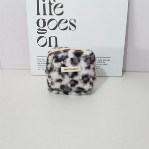 Detail shot of leopard print plush pouch showing top zipper and May Rabbit brand label