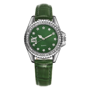 Détail macro d'une montre à cadran vert avec index étoilés et lunette en cristal