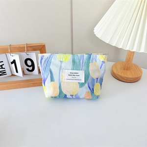 Close-up of floral canvas makeup bag featuring orange tulips and a metal zipper closure