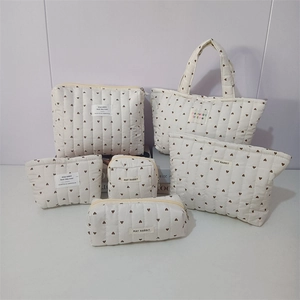 Detailed set of cream quilted cotton storage bags with brown heart patterns and tags